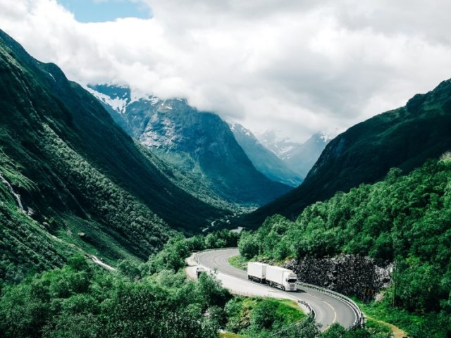 Truck driving on a highway between mountains