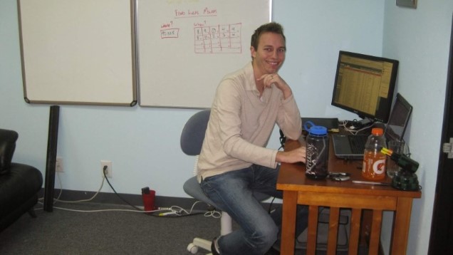 Ryan Charles sitting at his first desk at HireAHelper