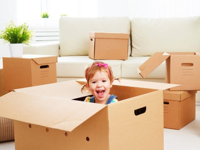 Child smiling inside of a moving box