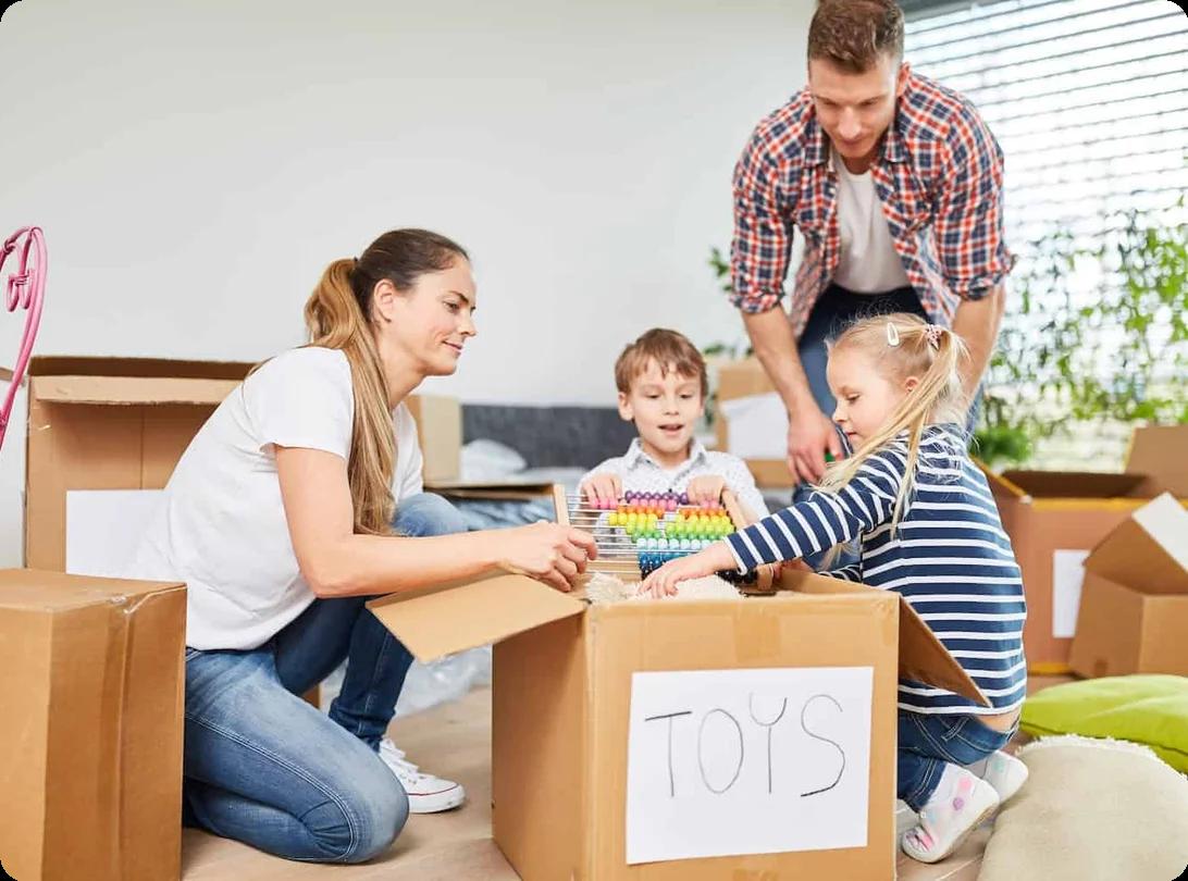 A family helps their children pack toys into a box