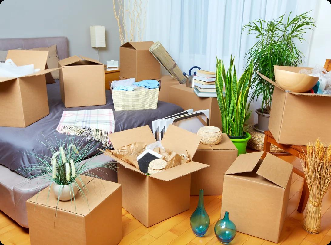 Cardboard moving boxes packed and ready in the bedroom of a new home