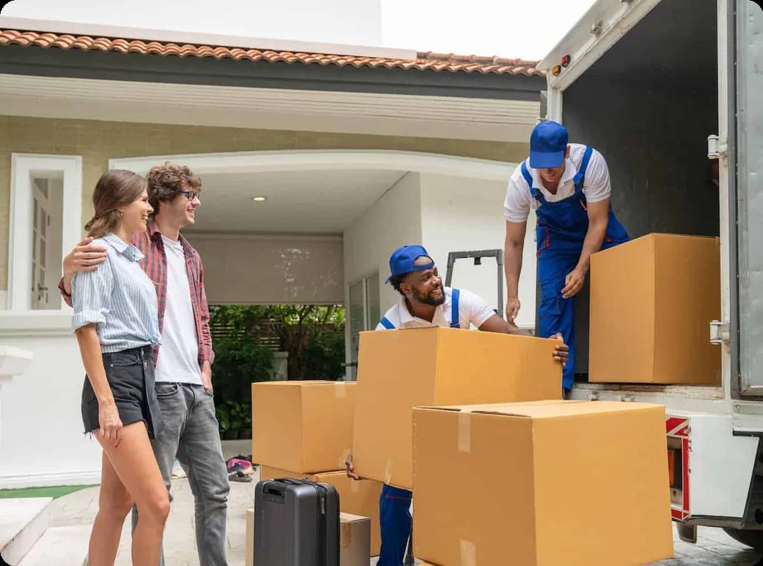 a couple watches two movers load a truck with boxes