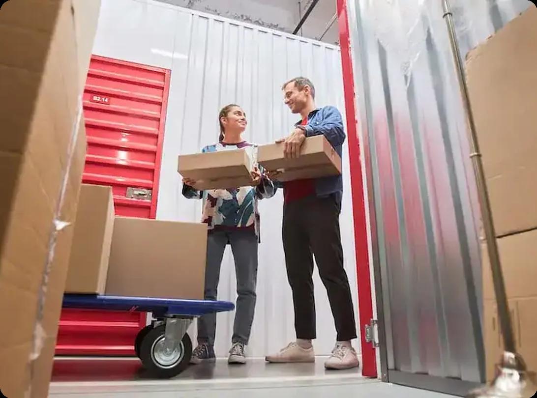 Couple organizing moving boxes inside a self-storage unit