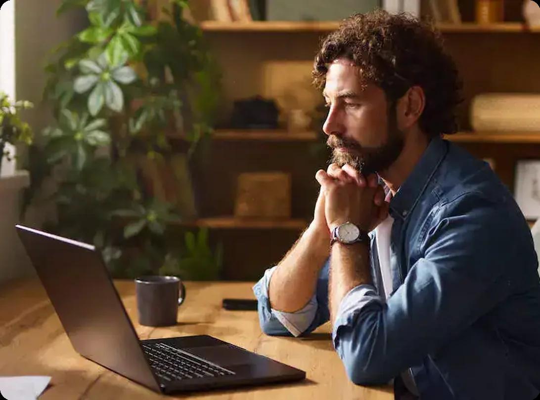 Man working on a laptop at home comparing reviews of local moving companies