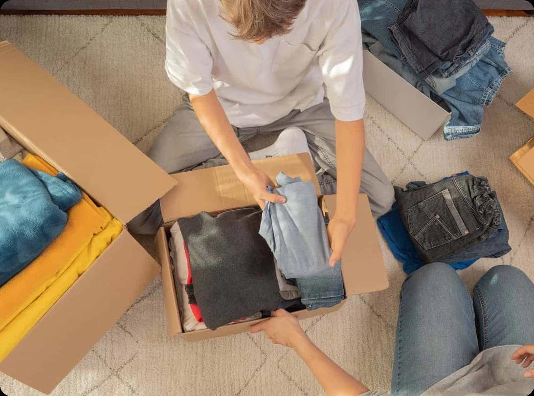 An arial shot of people packing clothing into various moving boxes