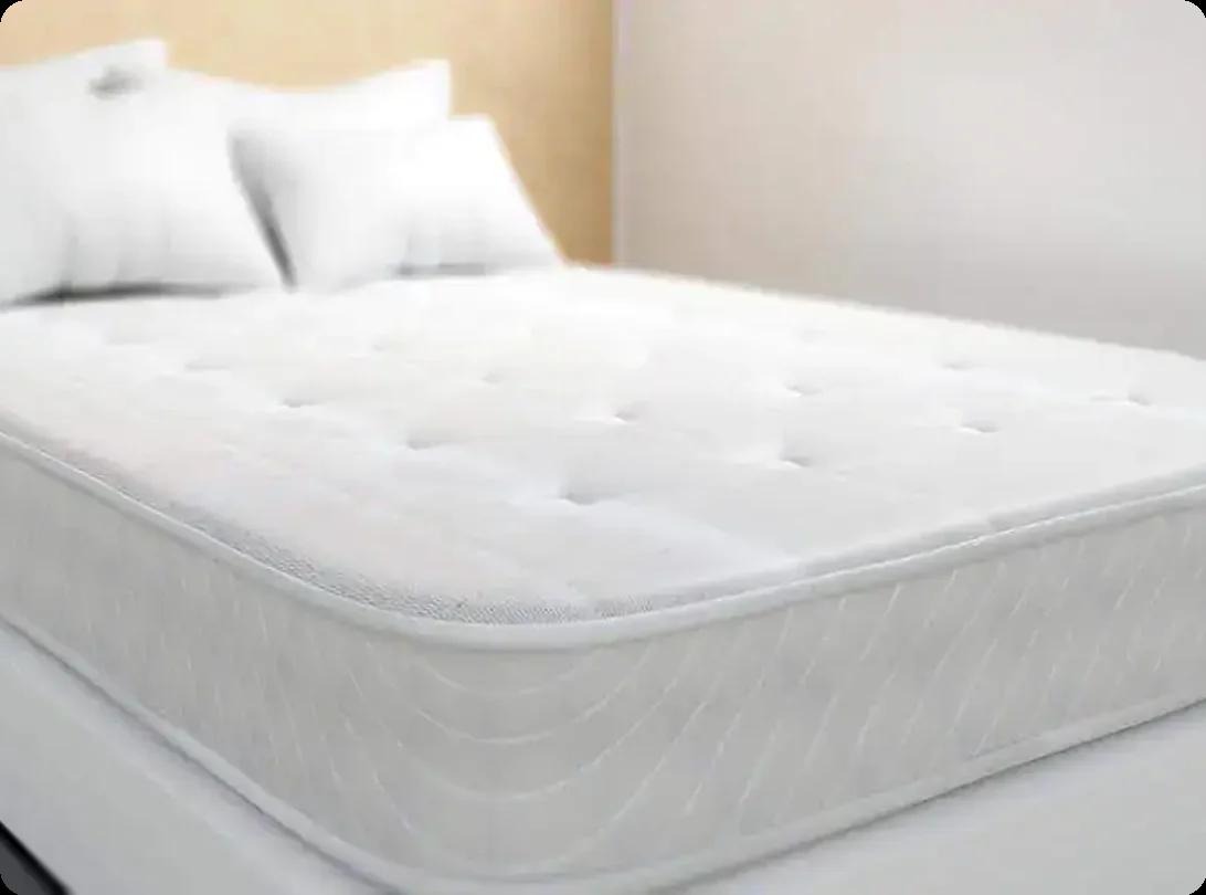 Clean mattress on a bed frame in a bedroom, ready for donation