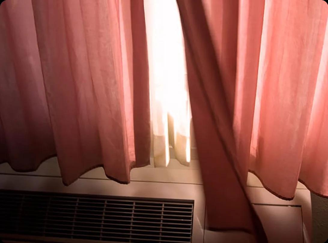 Curtains being carefully folded and placed in a moving box with tissue paper to prevent wrinkles