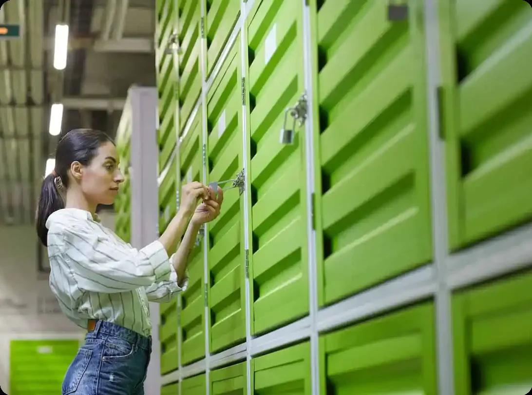 a woman unlocks the padlock on her storage unit.