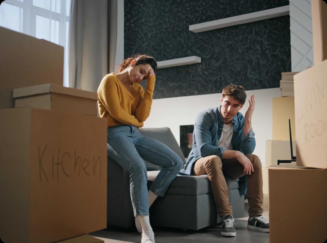 A couple looking stressed over moving boxes