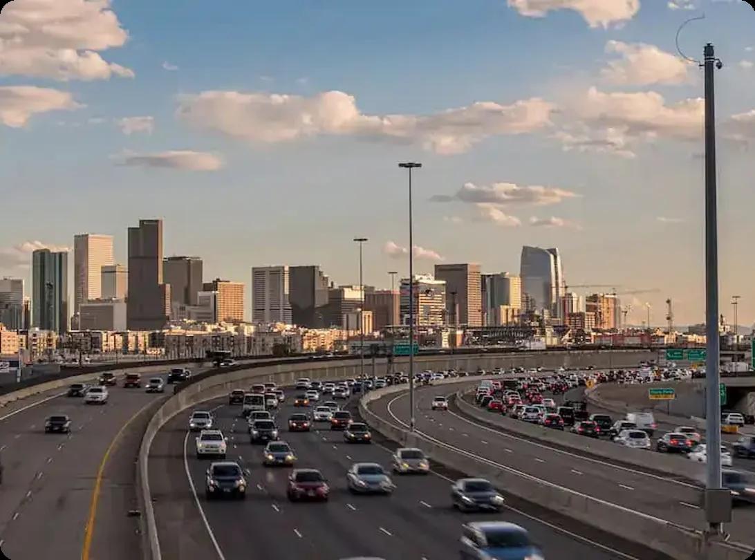 Denver CO skyline with highway traffic and downtown skyscrapers at sunset