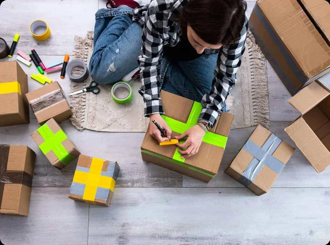 A woman tapes boxes shut with bright green and yellow tape