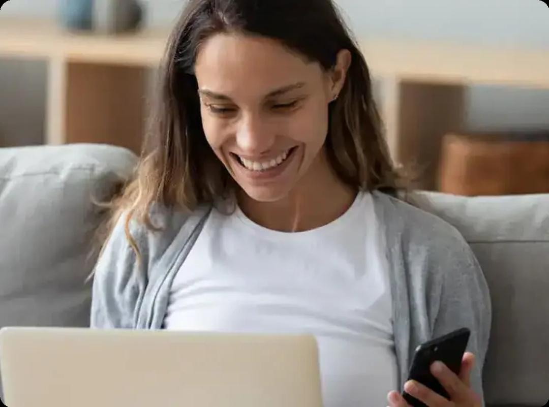 woman smiling with laptop and phone