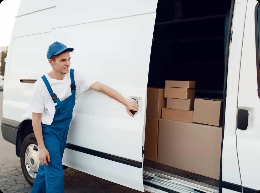 A mover closes the door to a moving truck with boxes inside