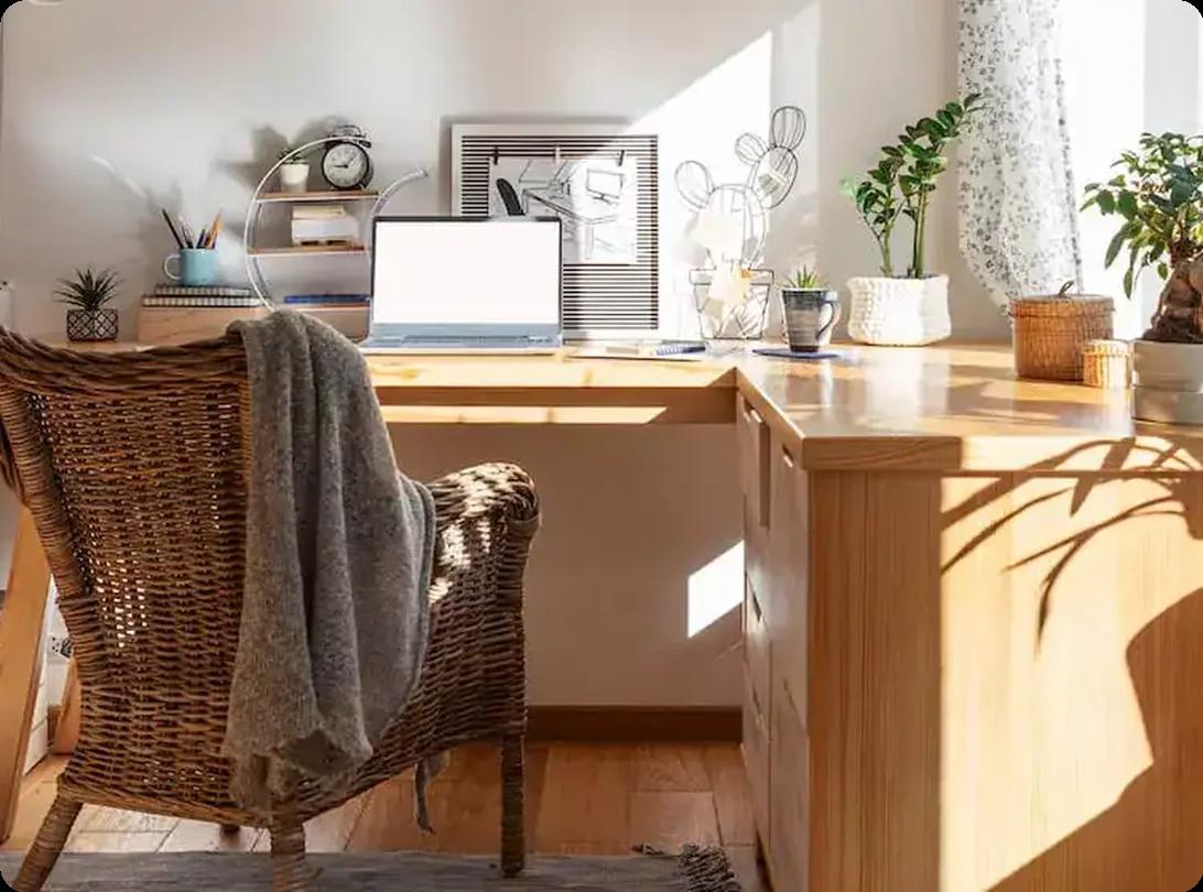 Bright home office with large wooden desk and laptop near window