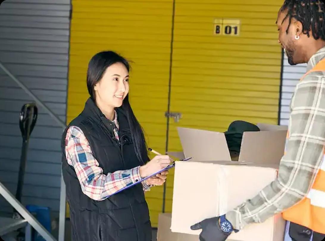 Customer signing paperwork for short-term storage at a facility with yellow doors