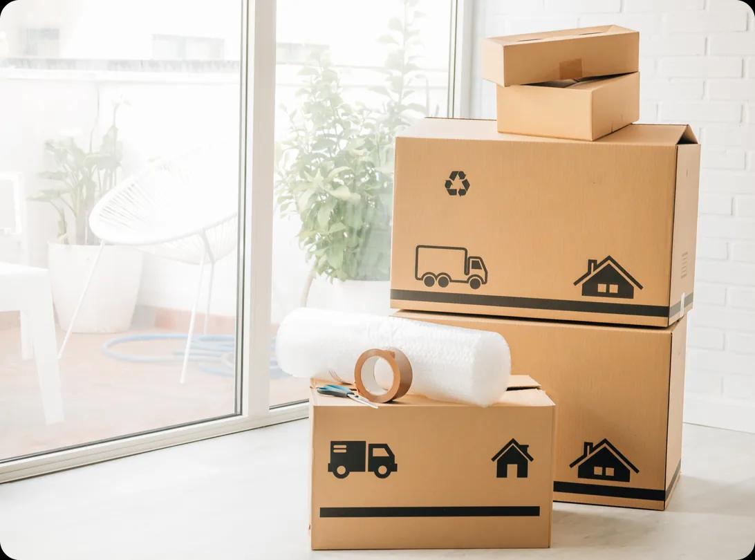 Stack of cardboard moving boxes with bubble wrap and packing tape