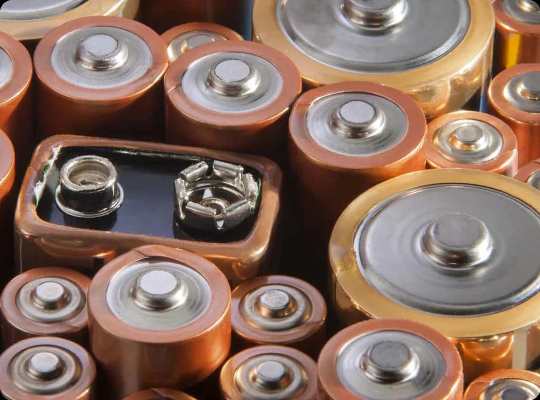 Cupped hands holding a colorful mix of AA, AAA, and button cell batteries