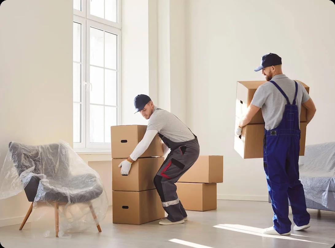 Two movers carry boxes out of an apartment