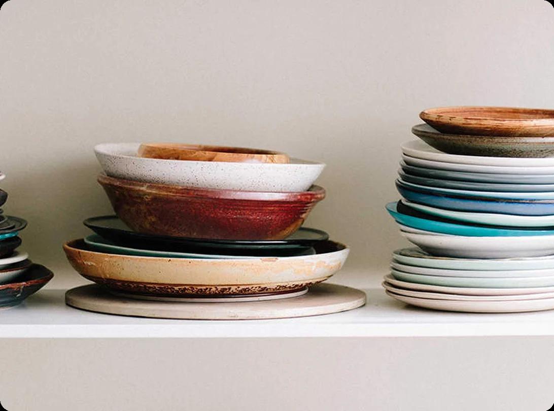 A dish-pack box partially filled with paper-wrapped dishes carefully arranged on edge