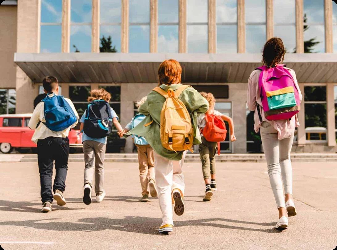 a group of children all wearing colorful backpacks run happily towards their school building