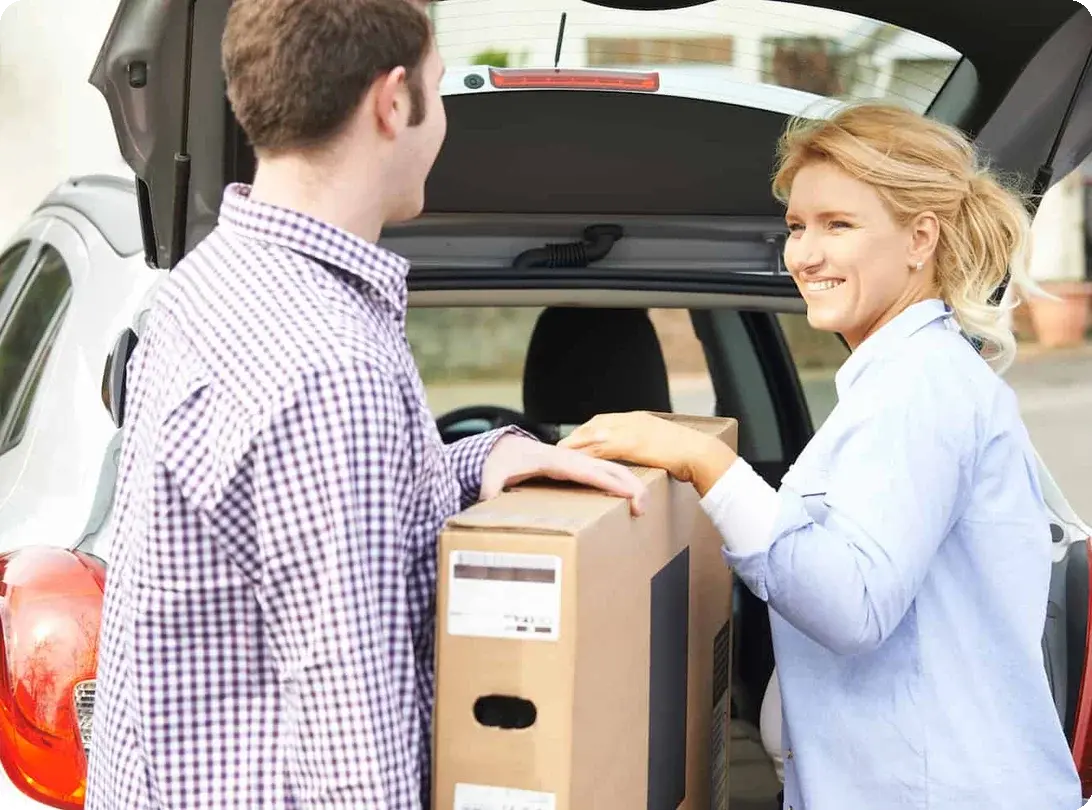 a couple packs a TV into their car in the upright position to prevent damage