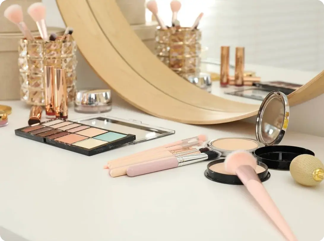 an image of makeup and accessories on a vanity table with a mirror