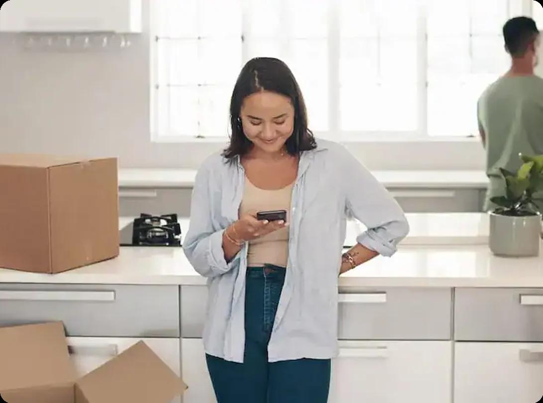 Smiling woman using her phone to explore moving apps for a relocation