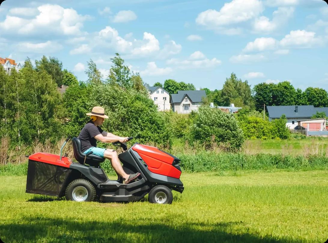 A riding lawn mower being securely strapped onto a utility trailer for transport to a new home