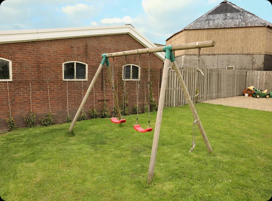 Spacious backyard with a swing set on a spring day