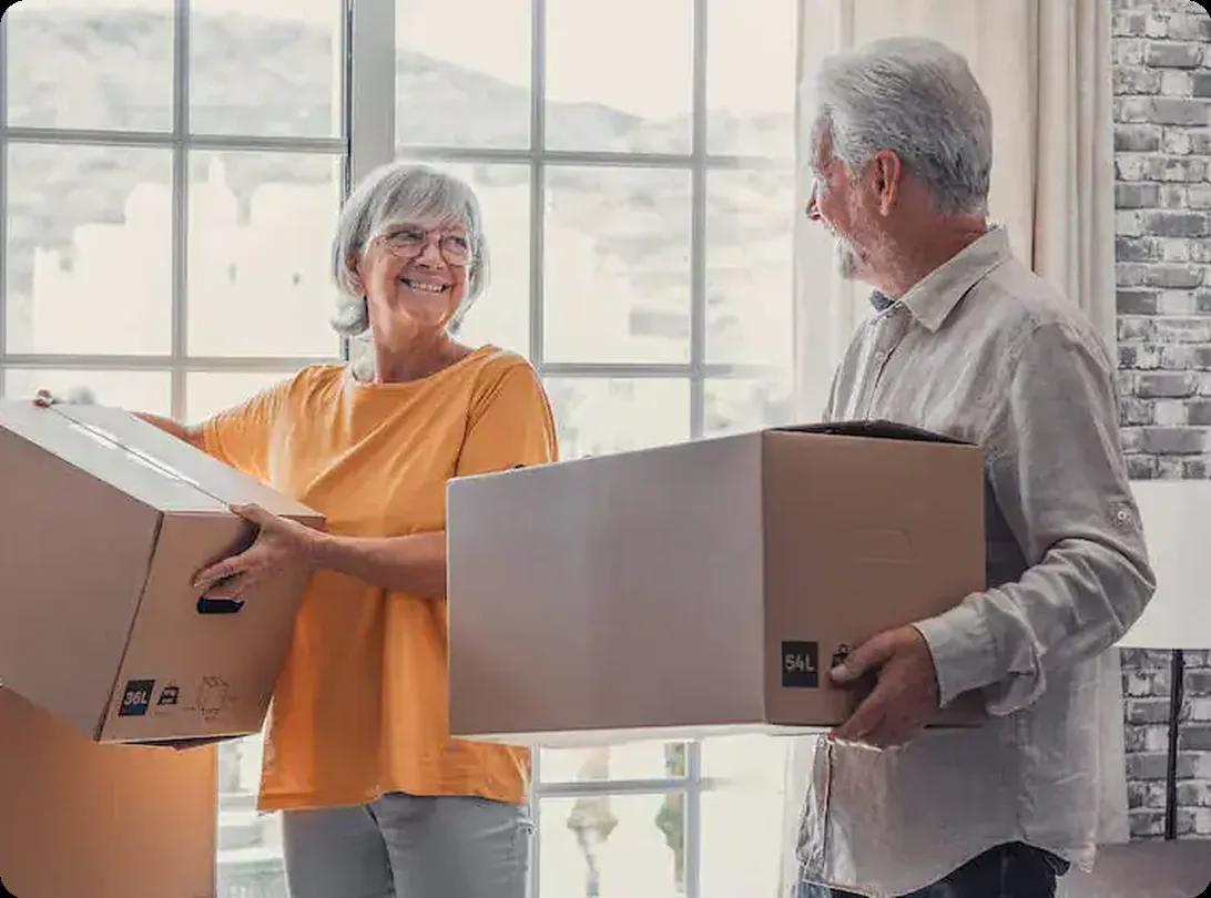Senior couple holding cardboard boxes while preparing for a move