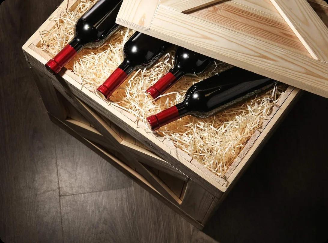 an image of wine settled on top of packing material in a wooden wine crate
