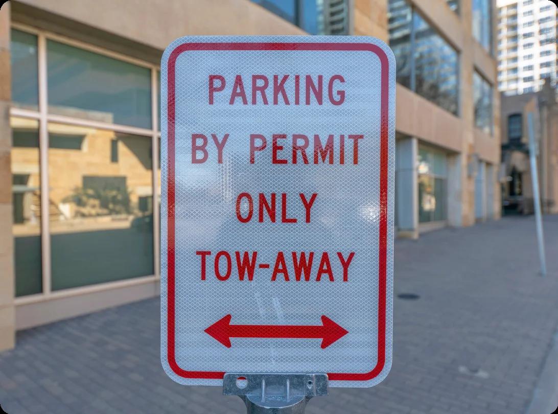 a red and white sign that says the area is only for parking with a permit