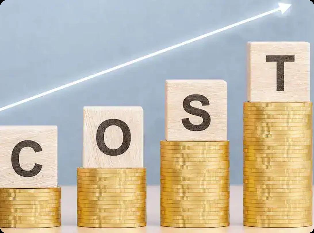 Wooden blocks spelling "COST" stacked on rising stacks of gold coins with an upward-trending arrow
