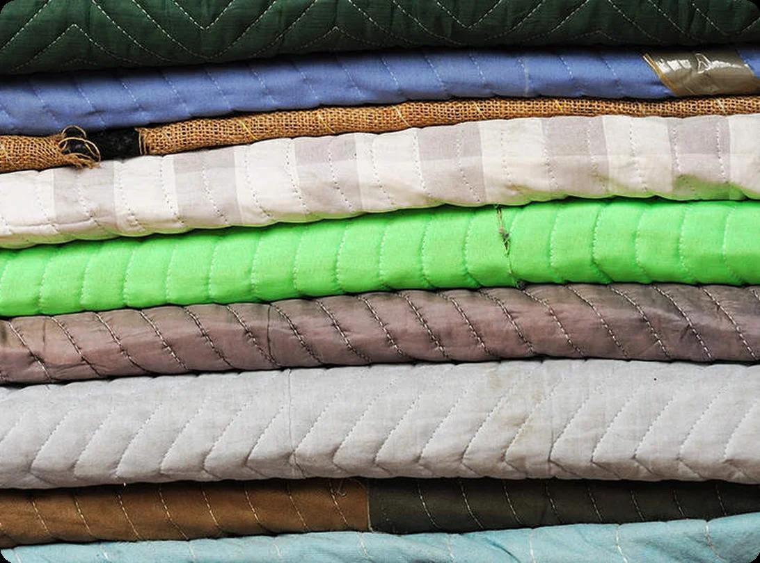 Stacked moving blankets and furniture pads ready to protect items during a move