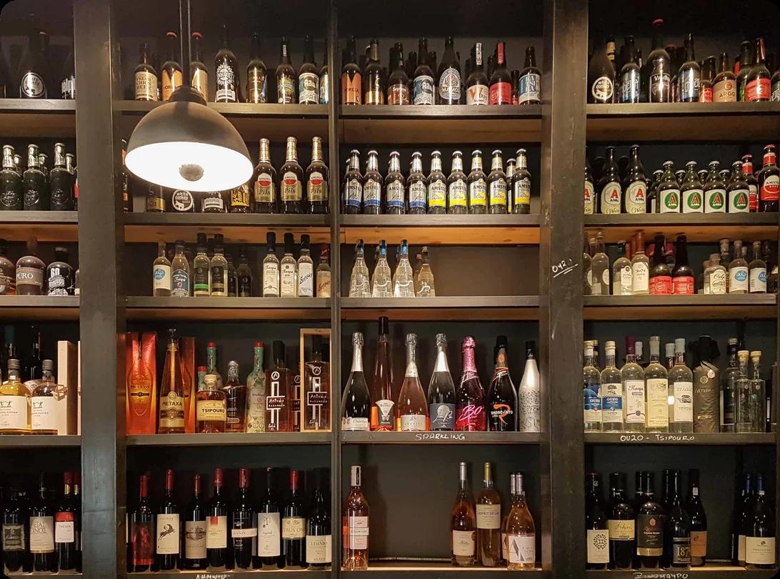 Several wine bottles of different types sit on a table and are packed into cardboard boxes for a move