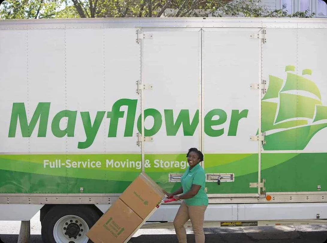 A Mayflower long-distance moving truck with the iconic green-and-yellow branding loaded for a cross-country move