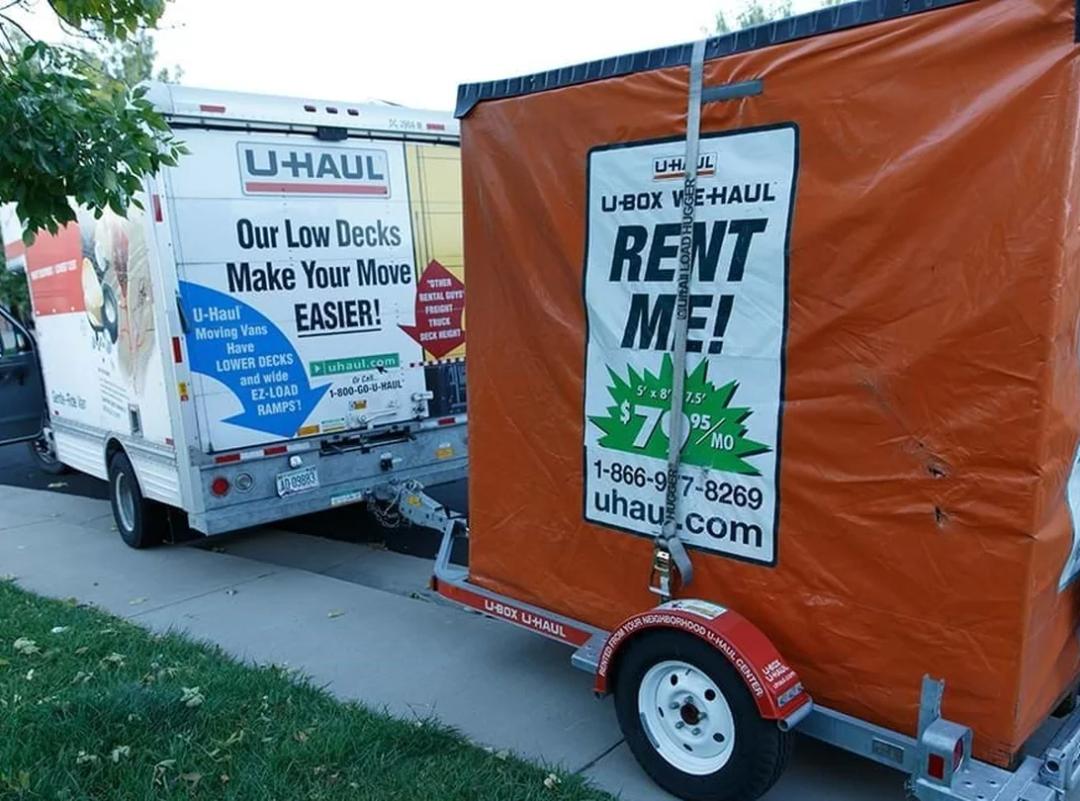 a u-haul u-box plywood moving and storage container parked in a residential driveway