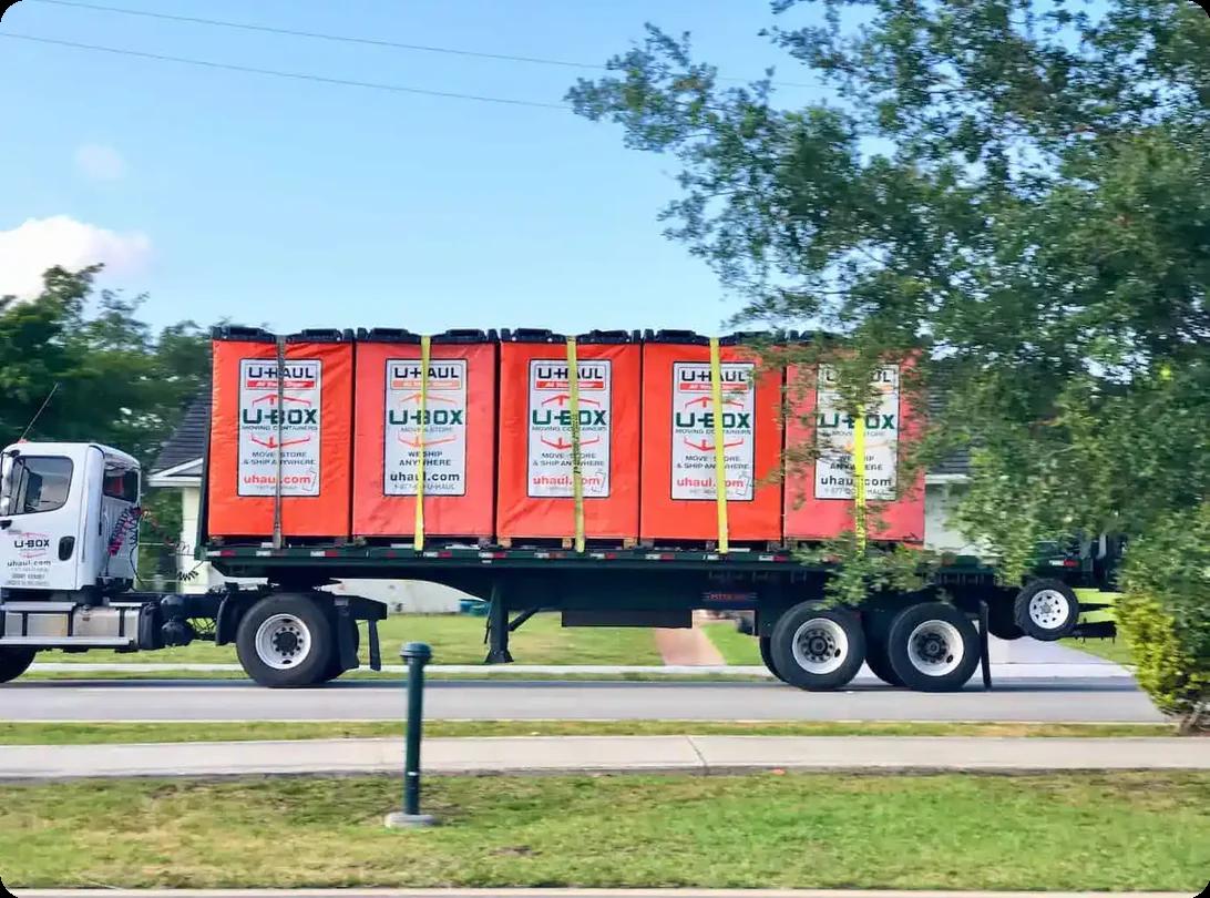 U-Haul U-Box moving containers loaded on flatbed truck for transport