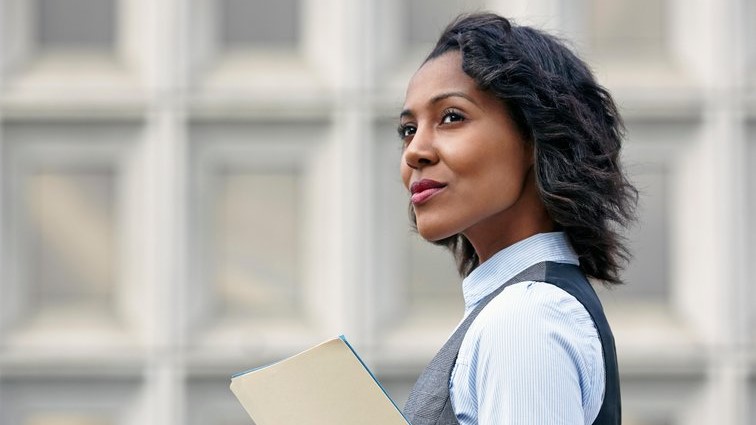 Woman smiling with a folder in her hand