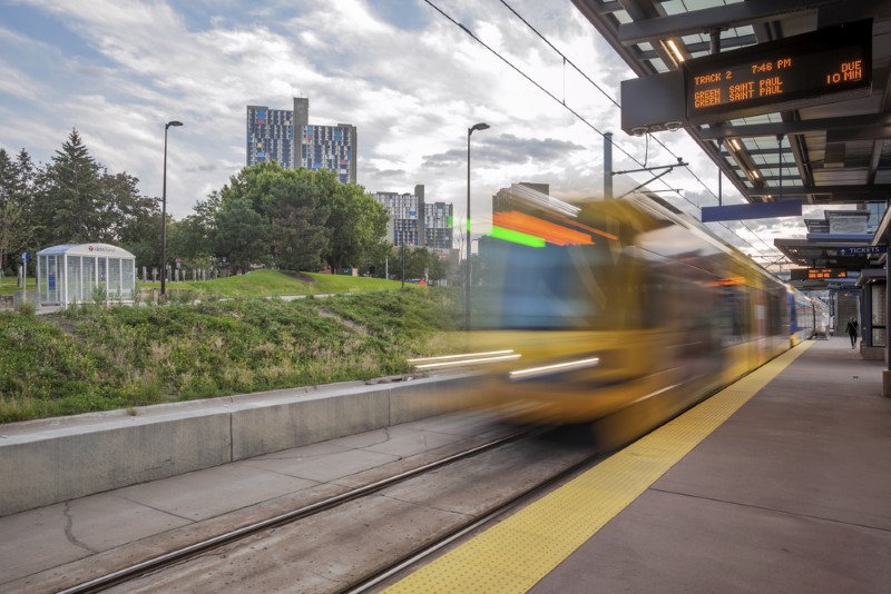 A timelapse of a light rail train arriving at a Minneapolis station on a summer afternoon