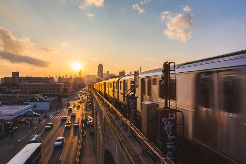 An NYC subway travels into the city at sunset in New York City, New York