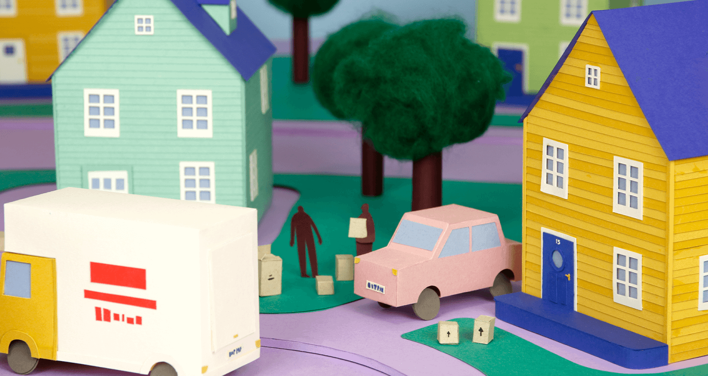 Paper cutout of house and moving truck being loaded