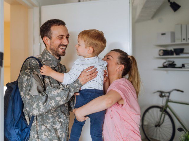 Man and woman holding their child and smiling